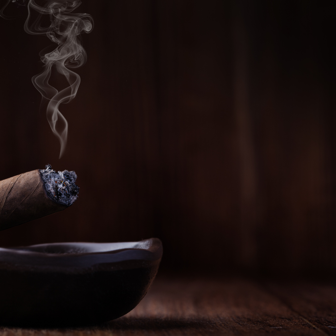 Cigar with smoke rising against a wood background