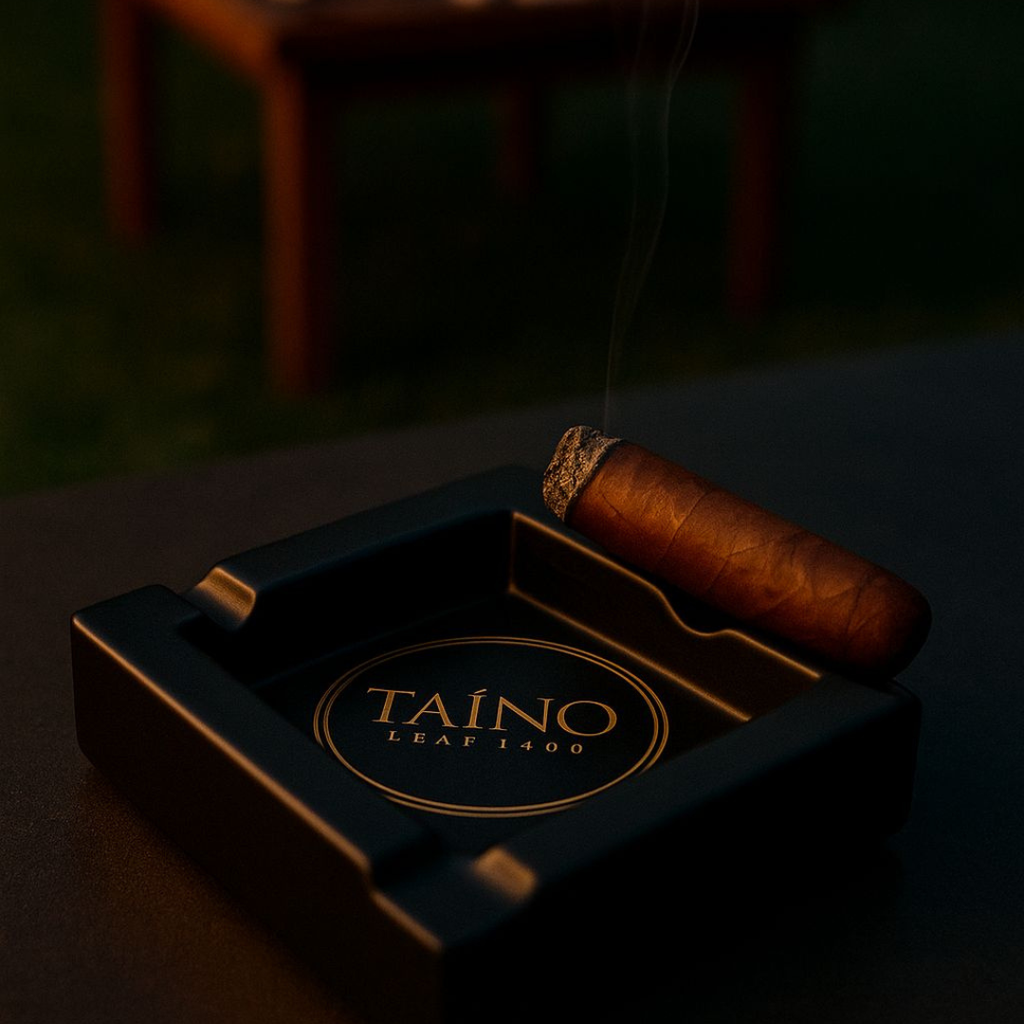 Cigar in a black ashtray with 'Taino Leaf 1400' branding on a dark background