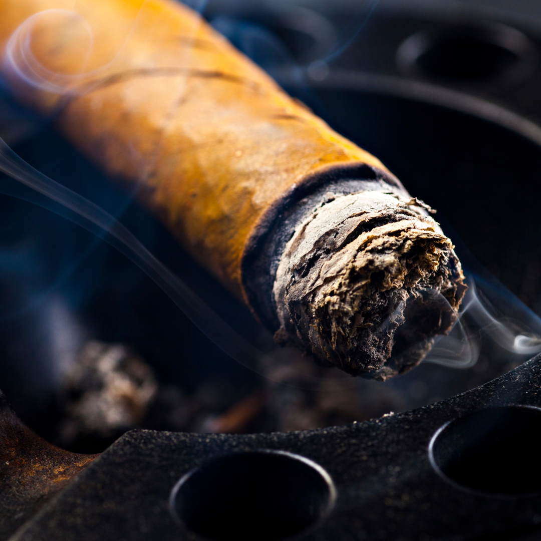 Close-up of a smoking cigar on a dark background